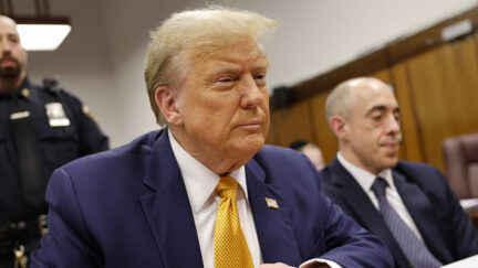 Former President Donald Trump sits and crosses his hands as he appears at Manhattan criminal court before his trial in New York, Tuesday, May 14, 2024.